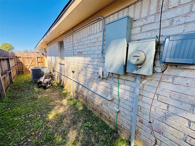 view of home's exterior with central air condition unit, a fenced backyard, and brick siding