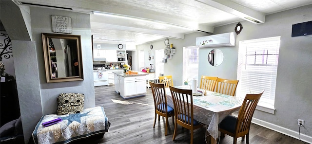 dining space with beamed ceiling, a healthy amount of sunlight, dark wood-type flooring, and a wall unit AC