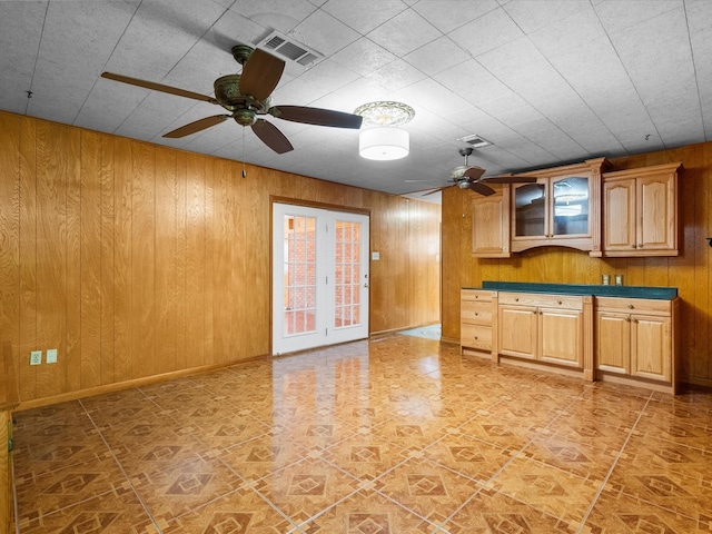 kitchen with dark countertops, baseboards, wooden walls, and visible vents