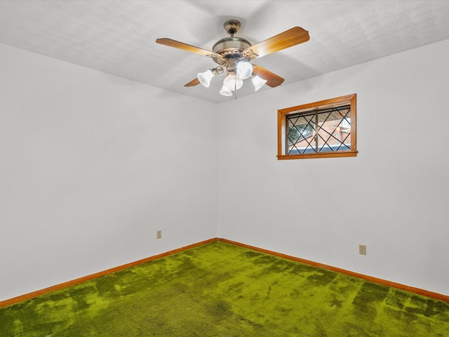 carpeted spare room featuring ceiling fan and baseboards