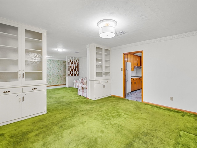 unfurnished dining area featuring light colored carpet, visible vents, baseboards, and wallpapered walls