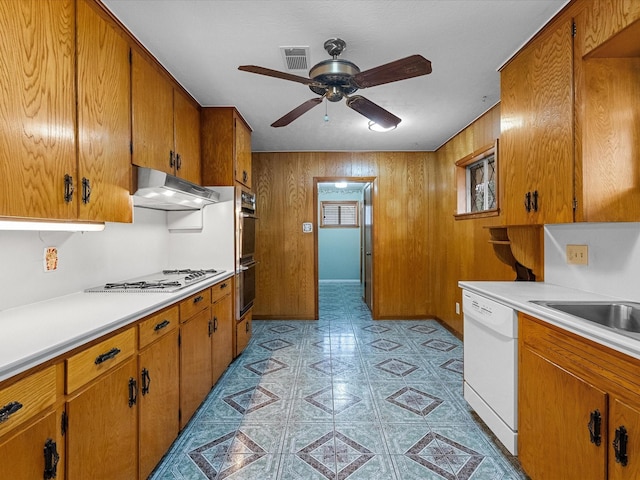 kitchen with visible vents, white dishwasher, light countertops, under cabinet range hood, and gas cooktop