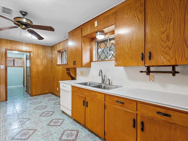 kitchen featuring brown cabinets, light countertops, visible vents, a sink, and dishwasher