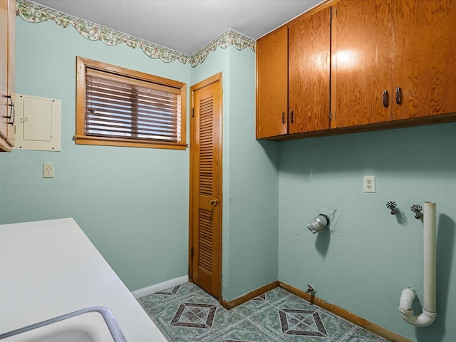 laundry room featuring cabinet space, electric panel, baseboards, hookup for a gas dryer, and hookup for a washing machine