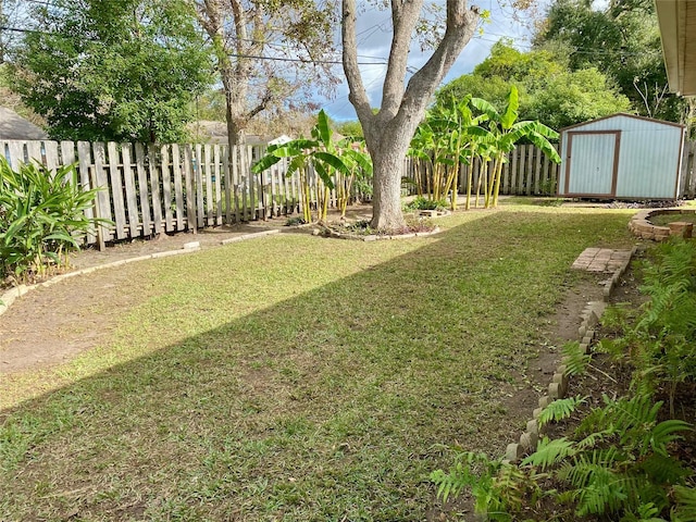 view of yard featuring an outbuilding, a fenced backyard, and a shed