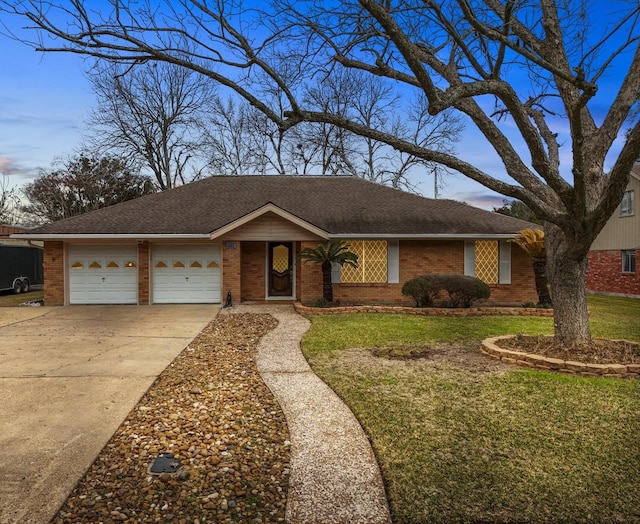 view of front of property featuring a front yard, concrete driveway, brick siding, and an attached garage