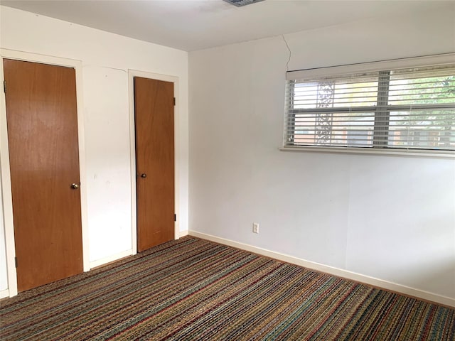 unfurnished bedroom featuring dark carpet