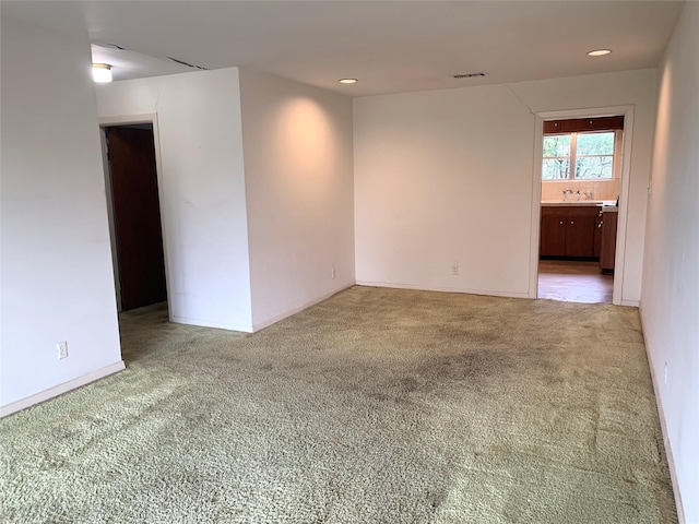 carpeted spare room with sink