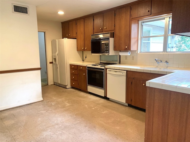 kitchen featuring tasteful backsplash, sink, white appliances, and tile countertops