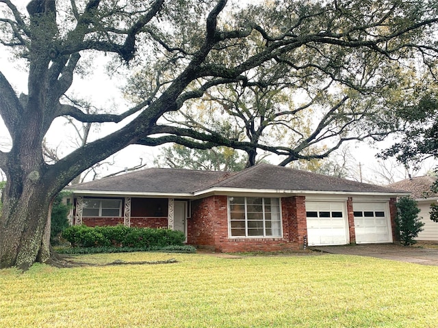 ranch-style house featuring a garage and a front lawn