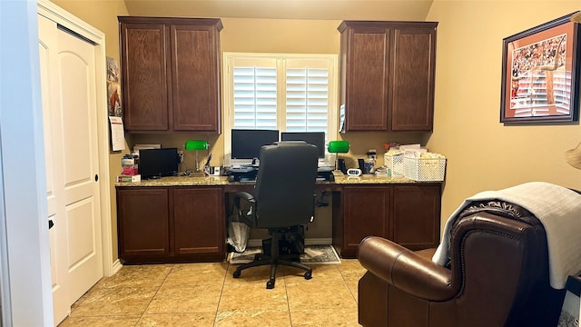 office space featuring built in desk and light tile patterned flooring