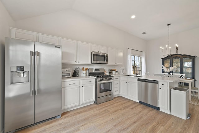 kitchen with visible vents, light countertops, light wood-style floors, stainless steel appliances, and a sink