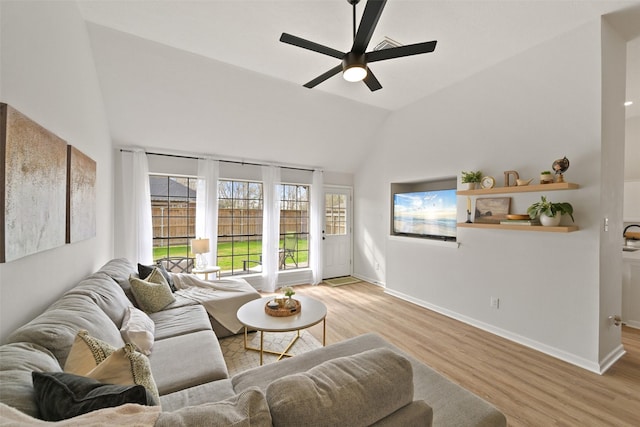 living area featuring light wood-type flooring, baseboards, ceiling fan, and vaulted ceiling