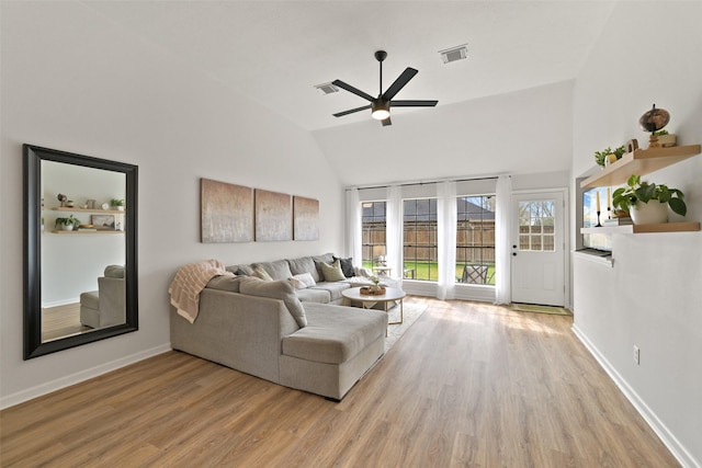 living room featuring visible vents, ceiling fan, baseboards, lofted ceiling, and wood finished floors