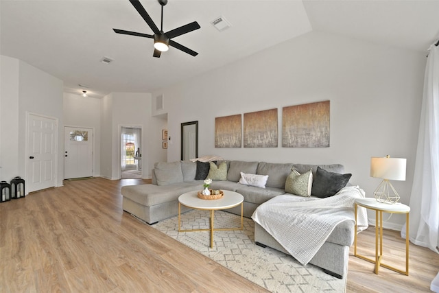 living area with a ceiling fan, light wood-style floors, visible vents, and high vaulted ceiling