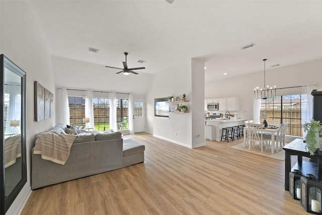 living room featuring visible vents, light wood-style floors, and ceiling fan with notable chandelier