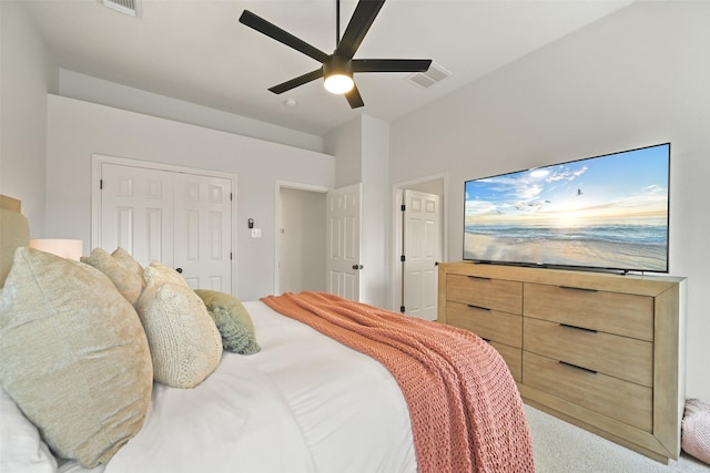 bedroom featuring ceiling fan, visible vents, a closet, and light carpet