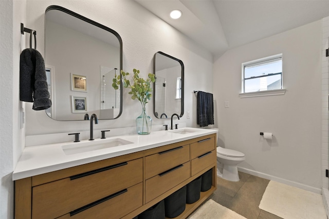 bathroom with double vanity, toilet, a shower with door, and a sink