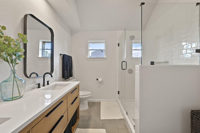 full bathroom featuring vanity, toilet, baseboards, and a stall shower