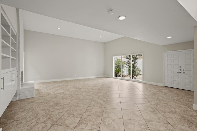 unfurnished living room with lofted ceiling and light tile patterned floors