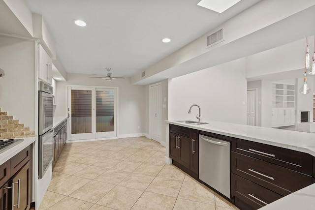 kitchen featuring light tile patterned flooring, sink, ceiling fan, stainless steel appliances, and dark brown cabinets