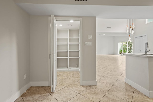 hall with sink and light tile patterned floors