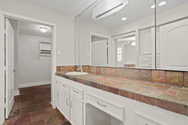 bathroom featuring vanity and tasteful backsplash