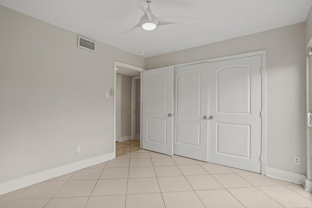 unfurnished bedroom with ceiling fan, a closet, and light tile patterned floors