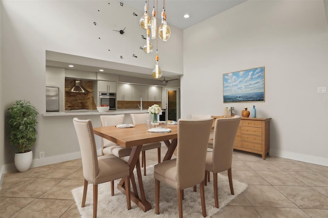 dining area with light tile patterned flooring and a towering ceiling