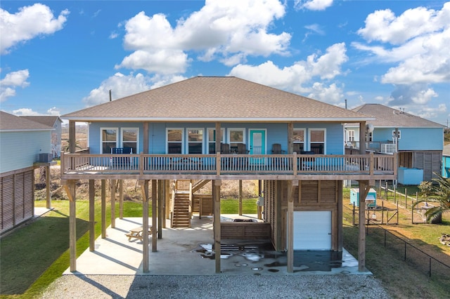 back of house featuring covered porch, cooling unit, and a lawn