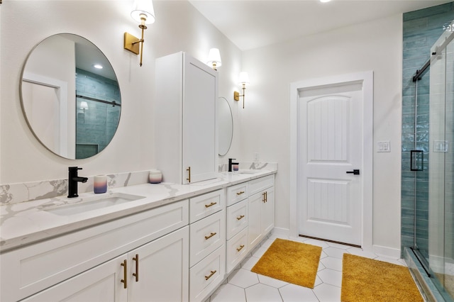 bathroom with a shower with door, vanity, and tile patterned floors