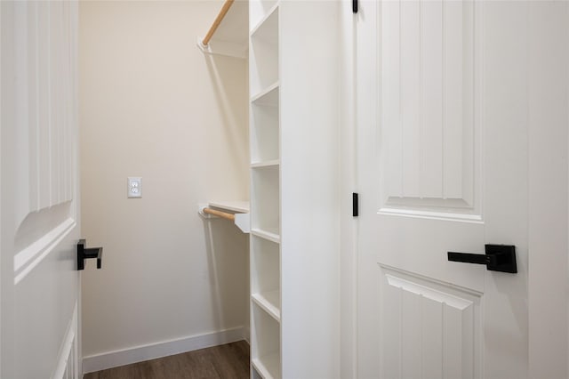 walk in closet with dark hardwood / wood-style floors