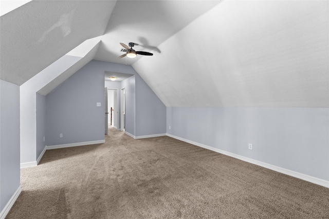 additional living space with a ceiling fan, vaulted ceiling, carpet floors, and baseboards