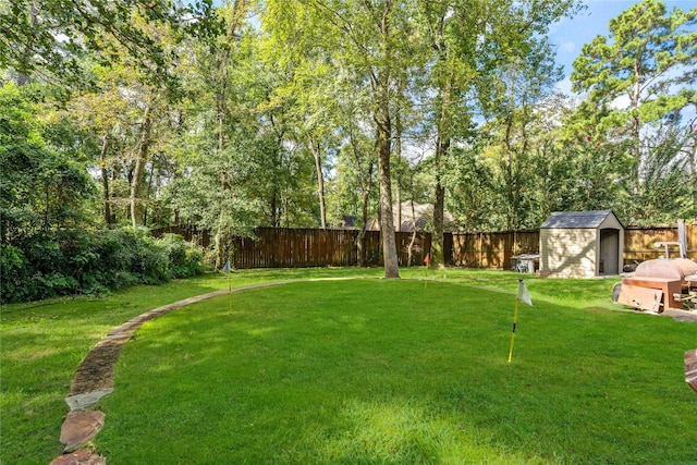 view of yard with an outbuilding, a fenced backyard, and a shed