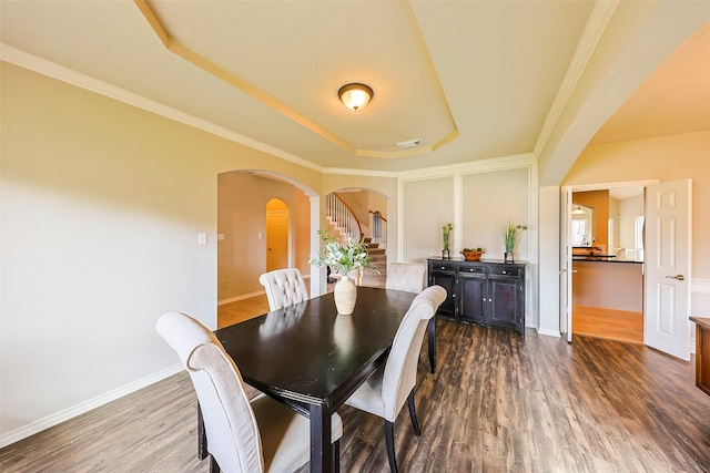 dining area featuring crown molding, dark hardwood / wood-style floors, and a tray ceiling