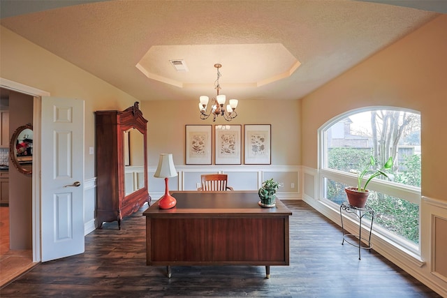 office area featuring an inviting chandelier, dark wood-type flooring, a raised ceiling, and a textured ceiling