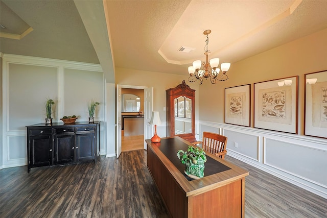 dining space with dark wood-type flooring, a tray ceiling, a chandelier, and a textured ceiling