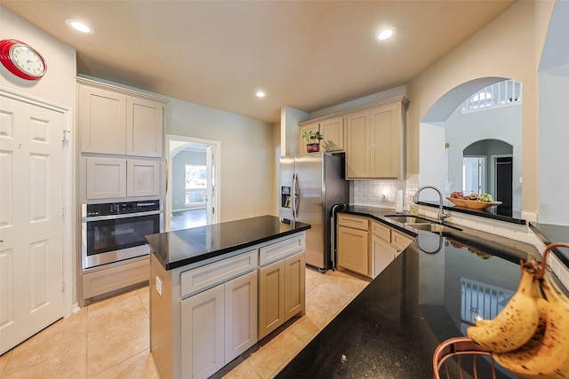 kitchen with stainless steel appliances, sink, light tile patterned floors, and backsplash