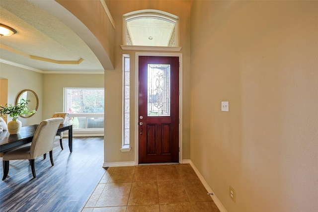 tiled entryway featuring ornamental molding