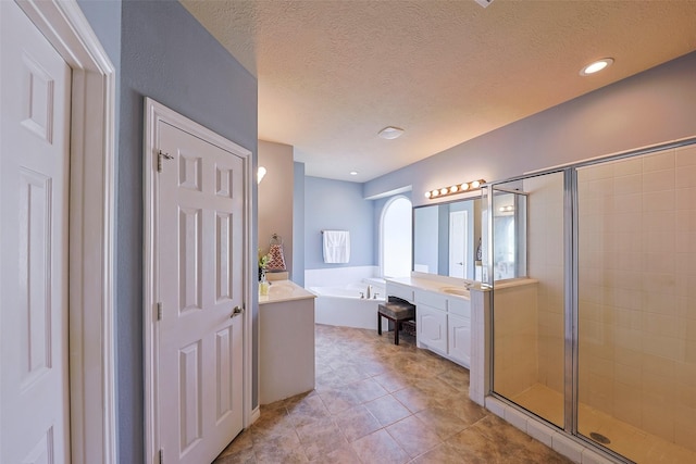 bathroom featuring vanity, shower with separate bathtub, tile patterned flooring, and a textured ceiling