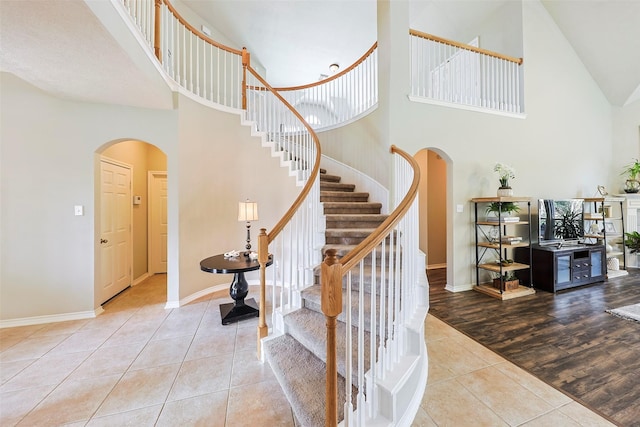 staircase featuring a high ceiling and tile patterned floors