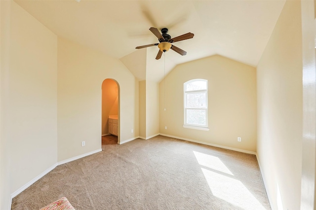 spare room featuring lofted ceiling, light carpet, and ceiling fan