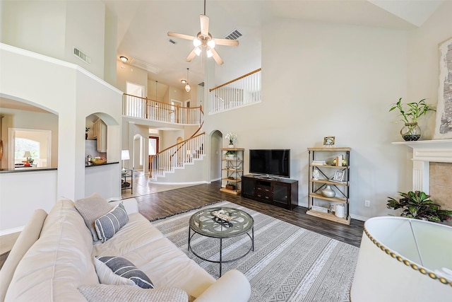 living room with a wealth of natural light, dark wood-type flooring, high vaulted ceiling, and ceiling fan