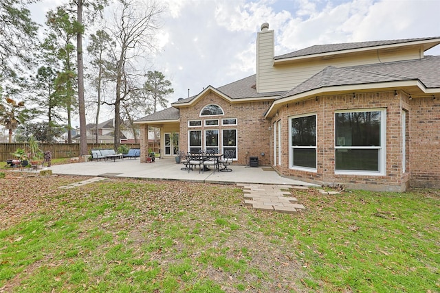 rear view of property with a lawn and a patio area