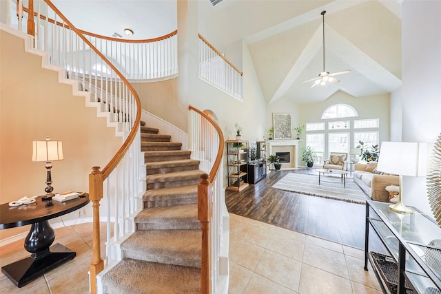 entrance foyer featuring light tile patterned flooring, a towering ceiling, and ceiling fan