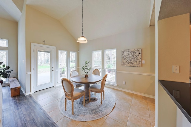 dining room featuring light tile patterned floors and high vaulted ceiling