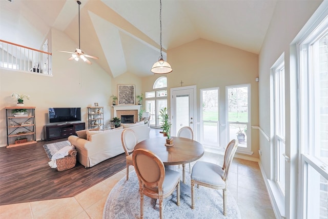 dining room featuring ceiling fan, high vaulted ceiling, and light tile patterned floors