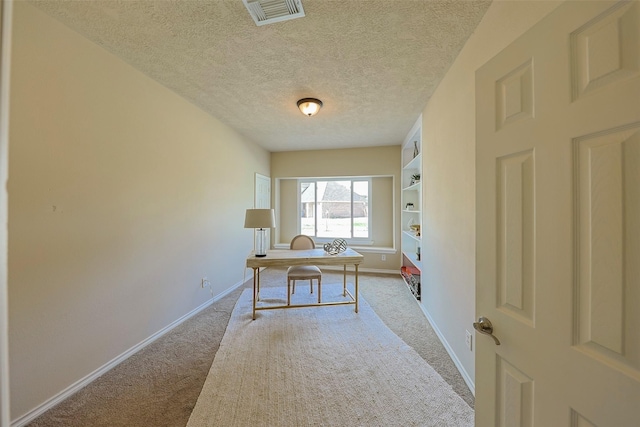 carpeted office featuring a textured ceiling