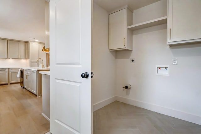 washroom with sink, cabinets, washer hookup, light parquet flooring, and hookup for an electric dryer