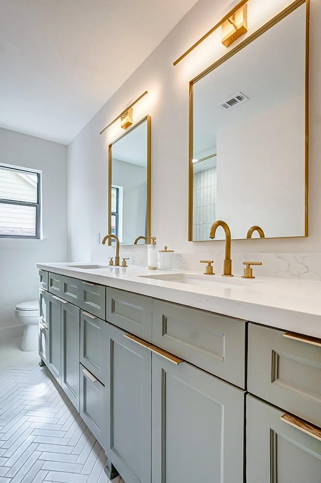 bathroom featuring vanity, parquet flooring, and toilet